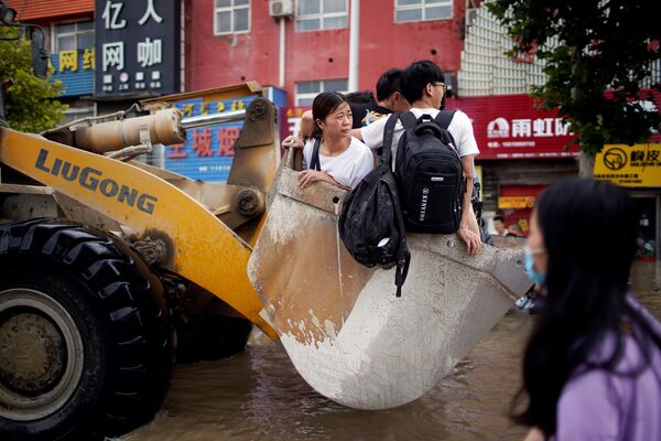 Люди, едущие на фронтальном погрузчике, после проливного дождя в Чжэнчжоу, Китай - Sputnik Азербайджан