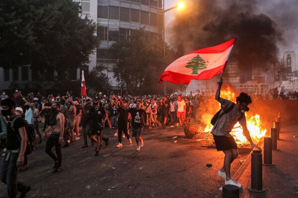 Beyrutda toqquşmalar zamanı Livan bayrağı ilə etirazçı. - Sputnik Azərbaycan