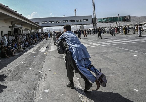 Волонтер с раненным афганцем в аэропорту Кабула. - Sputnik Азербайджан