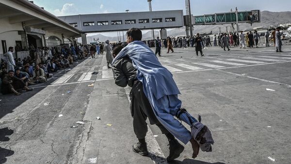 Волонтер с раненым афганцем в аэропорту Кабула - Sputnik Azərbaycan