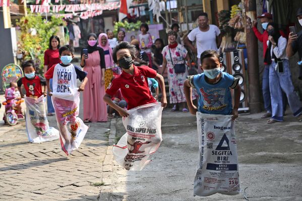 Дети в масках принимают участие в соревнованиях по бегу на мешках во время празднования Дня независимости в Джакарте, Индонезия. - Sputnik Азербайджан