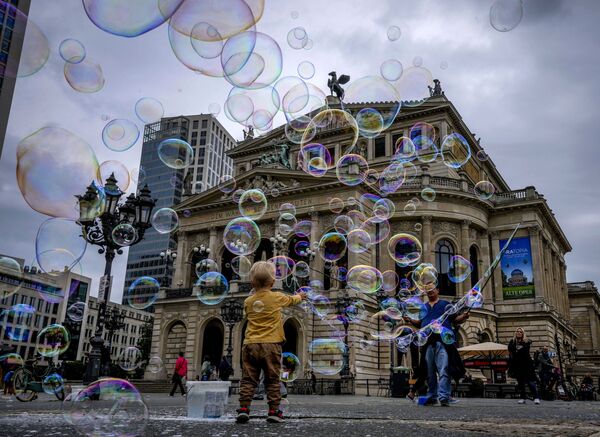 A boy plays with bubbles made by a soap bubble artist in front of the Old Opera in Frankfurt, Germany, Tuesday, Aug. 17, 2021. - Sputnik Азербайджан