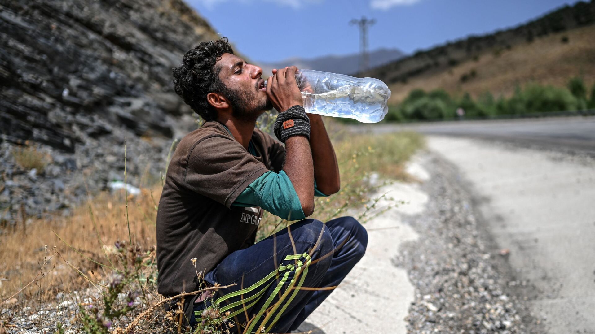 Афганский мигрант пьет воду в Татване - Sputnik Азербайджан, 1920, 01.11.2021