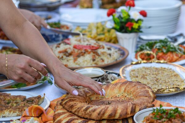 Посетитель дегустирует блюда на Неделе узбекской кухни в Азербайджане. - Sputnik Азербайджан