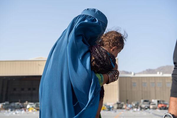 Женщина с ребенком во время эвакуации в Кабуле. - Sputnik Азербайджан