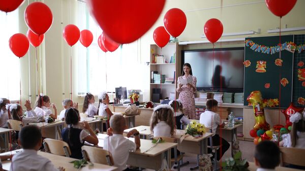 Первоклассники сидят за партой в классе в школе №71 в День знаний в Краснодаре - Sputnik Азербайджан