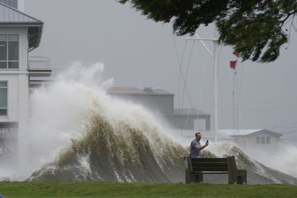 Мужчина фотографирует высокие волны на берегу озера Пончартрейн во время приближения урагана Ида в Новом Орлеане. - Sputnik Азербайджан
