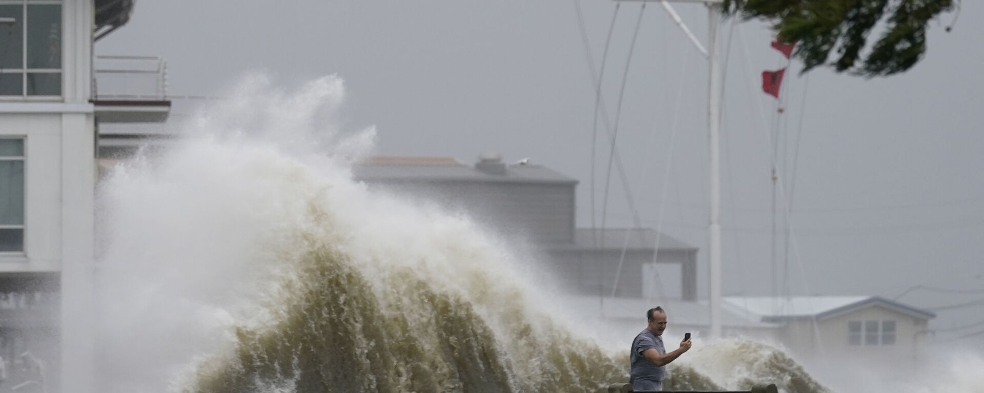 Мужчина фотографирует высокие волны на берегу озера Пончартрейн во время приближения урагана Ида в Новом Орлеане - Sputnik Азербайджан, 1920, 12.01.2024