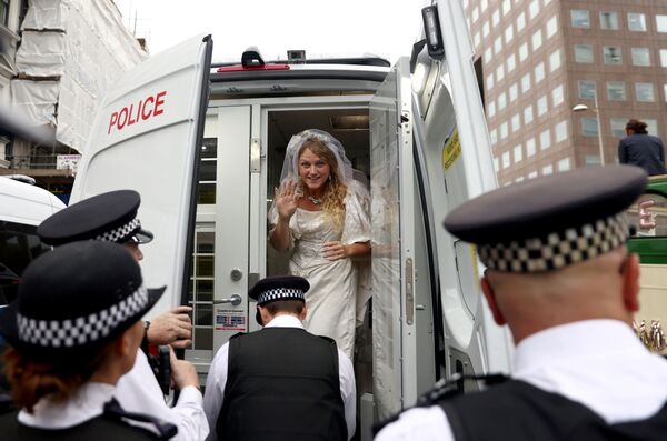 Активистка в свадебном платье в полицейской машине в ходе акции протеста Extinction Rebellion в Лондоне, Великобритания. - Sputnik Азербайджан
