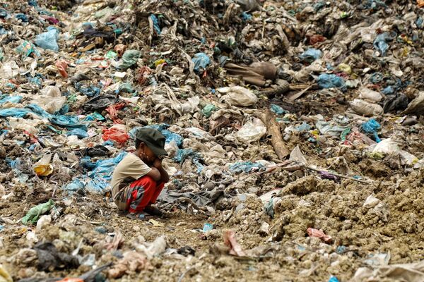 Сын сборщика мусора отдыхает, пока его отец ищет предметы, которые можно перепродать, на свалке в Алу Лием в Лхоксеумаве. - Sputnik Азербайджан