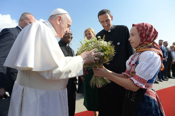 Папа Римский Франциск принимает букет от девушки в традиционном костюме в международном аэропорту Братиславы, Словакия. - Sputnik Азербайджан