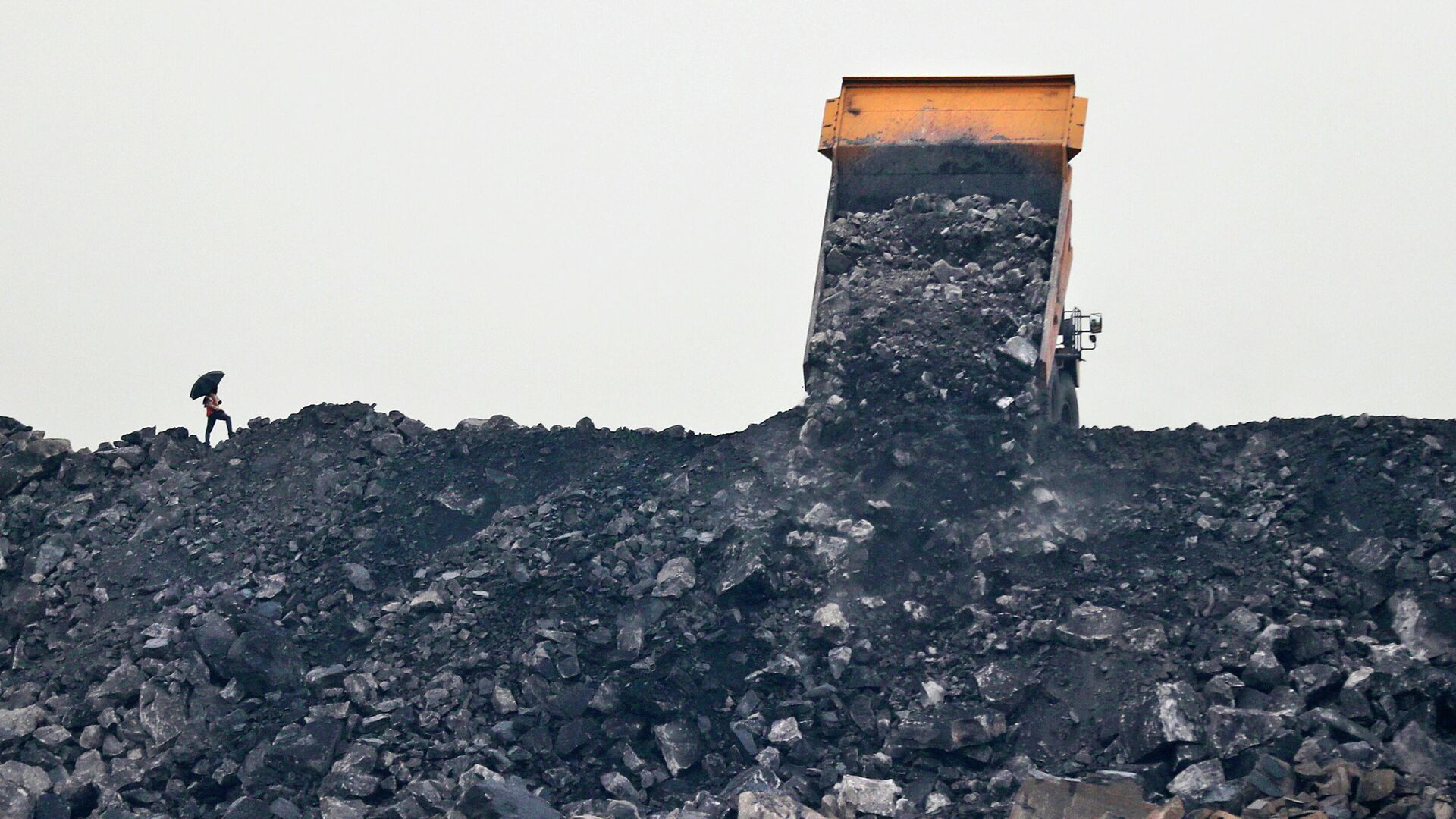 Рабочий наблюдает, как уголь выгружается из грузовика  - Sputnik Azərbaycan, 1920, 27.06.2022
