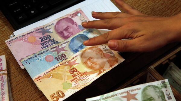  Сотрудник пункта обмена валюты демонстрирует турецкие лиры, фото из архива - Sputnik Азербайджан
