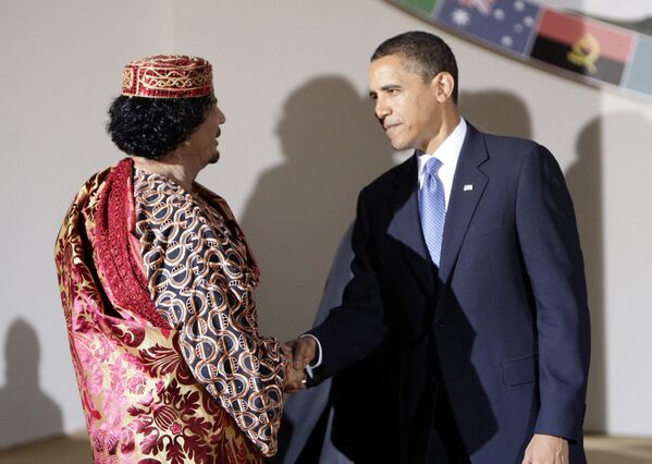 Президент США Барак Обама (справа) и лидер Ливии Муаммар Каддафи обмениваются рукопожатием во время саммита стран G8 в Аквиле, 9 июля 2009 года. - Sputnik Азербайджан