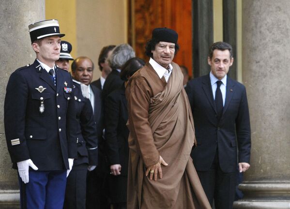 Ливийский лидер Муаммар Каддафи (в центре) покидает Елисейский дворец в Париже после встречи с президентом Франции Николя Саркози, 10 декабря 2007 года. - Sputnik Азербайджан