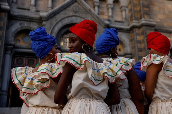 Члены гаитянской танцевальной группы ждут выступления во время первого ежегодного общественного мероприятия после пандемии в Бостоне, Массачусетс, США. - Sputnik Азербайджан