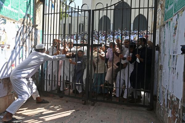 Протестующие взламывают запертые ворота Национальной мечети во время демонстрации после пятничной молитвы в Дакке. - Sputnik Азербайджан