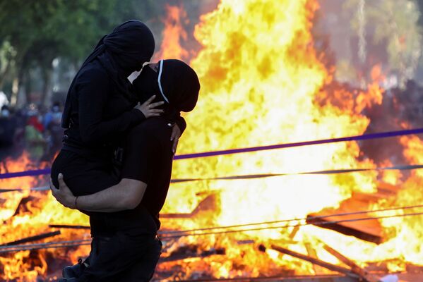 Демонстранты обнимаются во время акции протеста против правительства Чили. - Sputnik Азербайджан