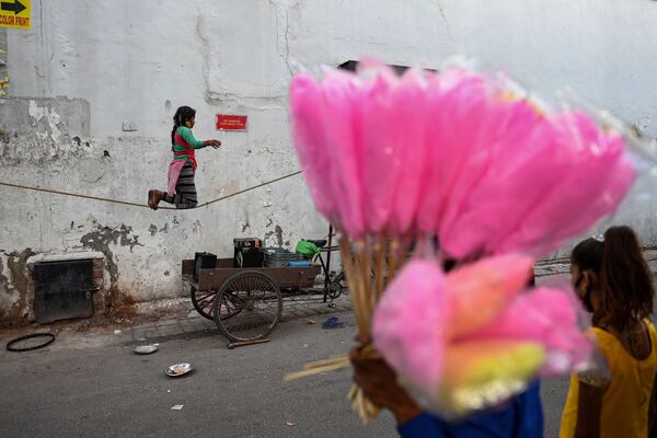 Девочка балансирует на канате во время уличного представления в Нью-Дели. - Sputnik Азербайджан