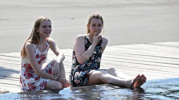 Девушки в жаркую погоду отдыхают у фонтана в ЦПКиО имени Горького в Москве, 26 июня 2021 года - Sputnik Азербайджан