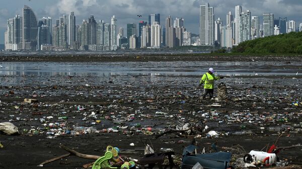 Мужчина собирает мусор, включая пластиковые отходы, на пляже Коста-дель-Эсте, в Панама-Сити, 19 апреля 2021 года - Sputnik Азербайджан