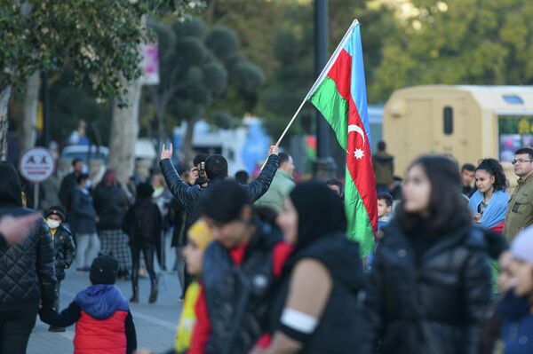 Повсюду видны цвета триколора – азербайджанский флаг гордо развевается на балконах домов, окнах машин, в руках и на плечах людей. - Sputnik Азербайджан