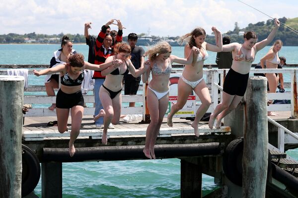 Люди прыгают в воду с пристани Оракеи, Новая Зеландия. - Sputnik Азербайджан