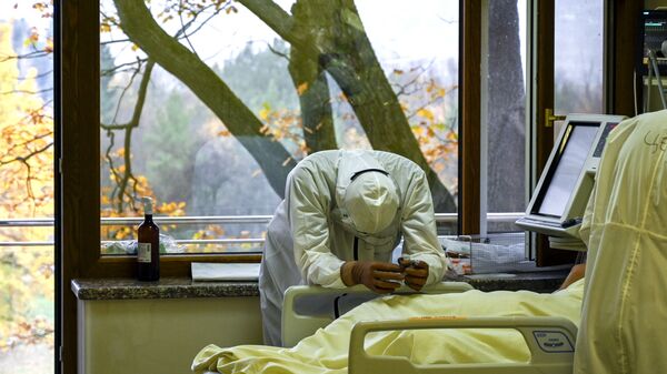 Медицинский работник рядом с пациентом в отделении интенсивной терапии больницы Лозенец в Софии - Sputnik Азербайджан