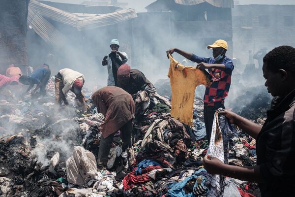 Торговцы разбирают завалы на месте сгоревшего рынка подержанной одежды в Найроби, Кения. - Sputnik Азербайджан