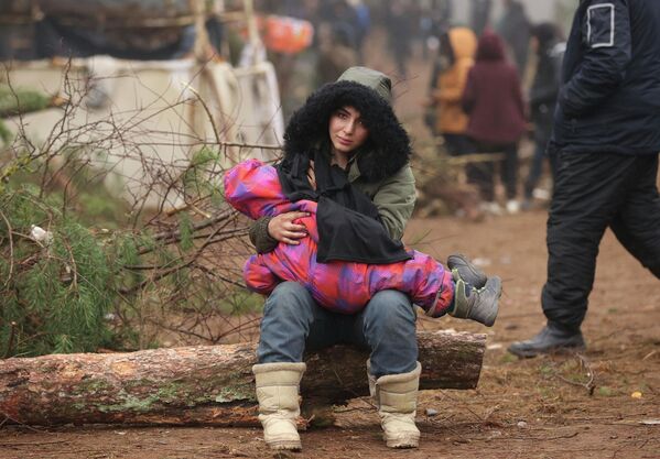 Женщина с ребенком на границе Беларуси и Польши недалеко от Гродно, 14 ноября 2021 года. - Sputnik Азербайджан