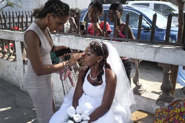 Женщина красит подружку невесты у церкви в Порт-о-Пренсе, Гаити. - Sputnik Азербайджан