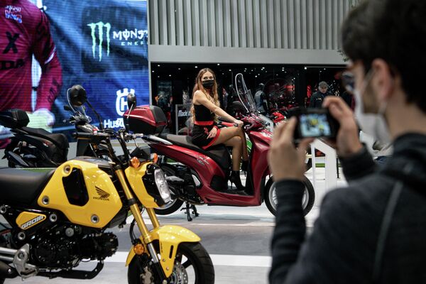 Мужчина фотографирует выставленный мотоцикл Honda на EICMA. - Sputnik Азербайджан