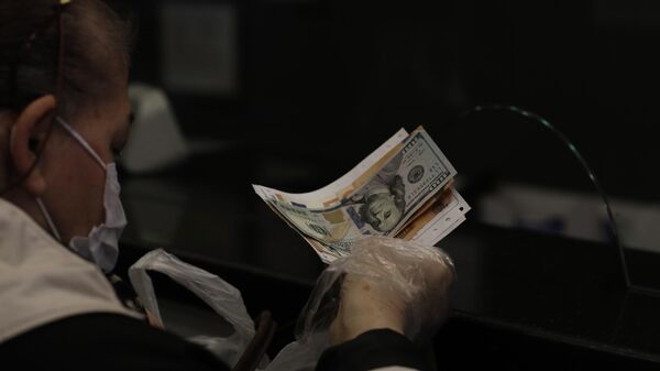 Женщина меняет турецкую лиру на доллары США и евро в пункте обмена валюты в Анкаре - Sputnik Азербайджан