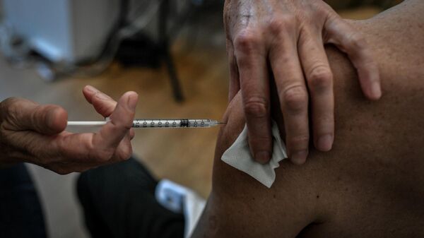 Медицинский работник вводит вакцину Covid-19 мужчине в центре вакцинации, фото из архива - Sputnik Азербайджан