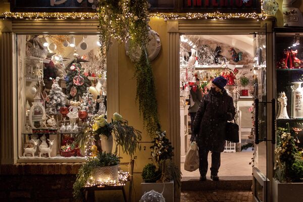Женщина в маске смотрит на рождественские украшения в магазине в Вильнюсе, Литва. - Sputnik Азербайджан