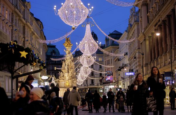 Люди ходят под рождественскими огнями в Вене, Австрия. Магазины и рестораны закрыты из-за падемии коронавируса. - Sputnik Азербайджан