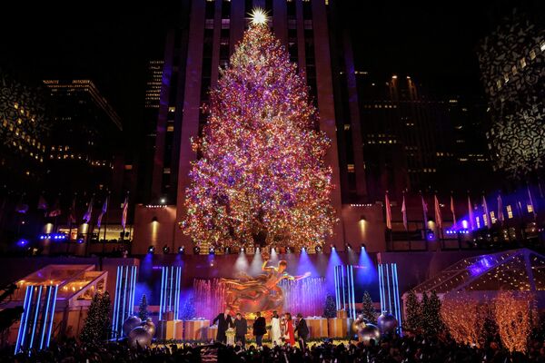 Люди наблюдают за 89-м зажжением рождественской елки Рокфеллер-центра в Нью-Йорке. - Sputnik Азербайджан