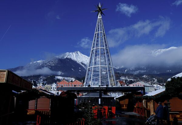 Люди стоят возле закрытых будок после того, как традиционный рождественский рынок был закрыт из-за четвертой национальной изоляции от коронавируса (COVID-19) в Инсбруке, Австрия. - Sputnik Азербайджан