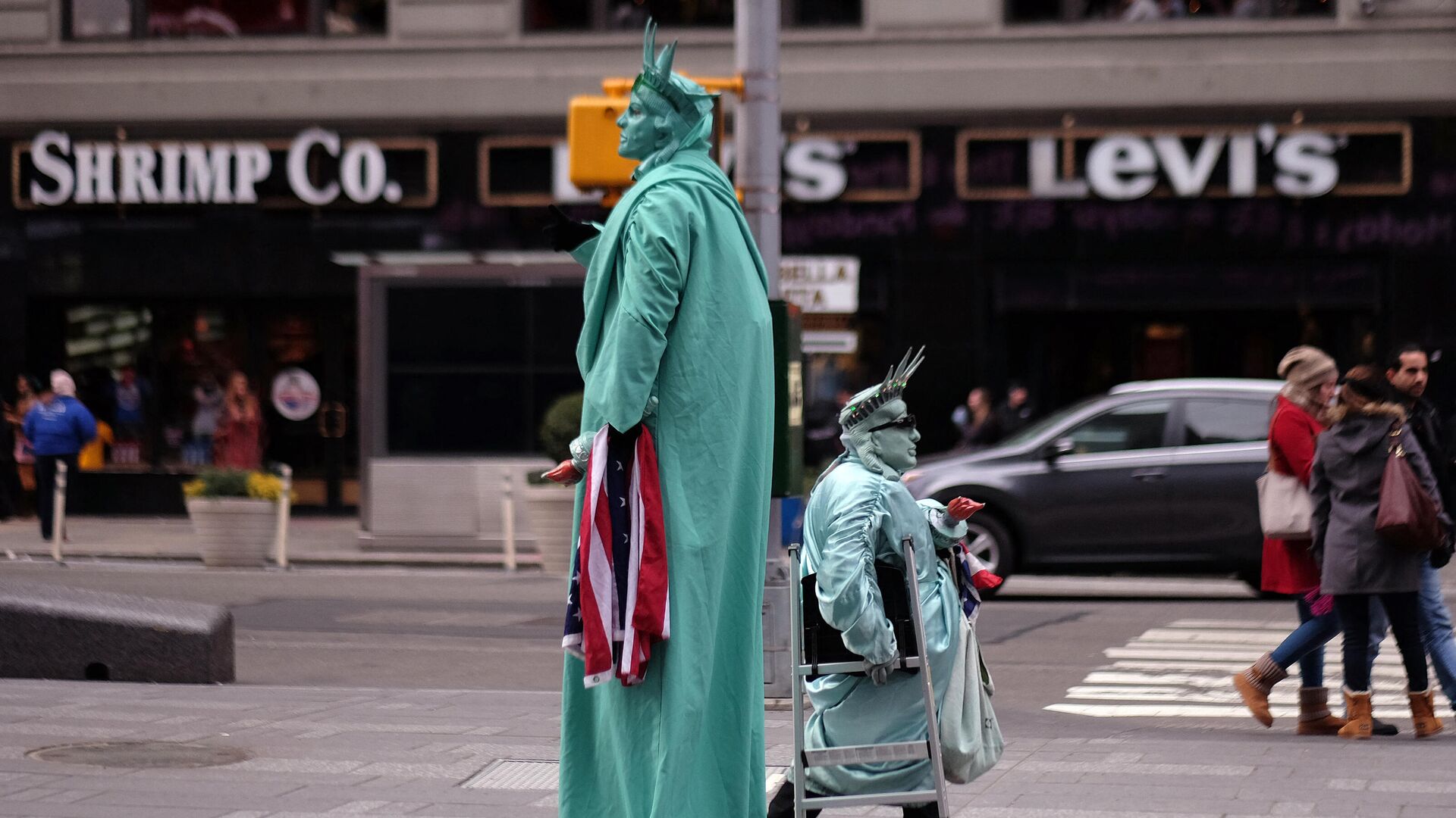 Двое мужчин, одетых как Статуя Свободы, ищут туристов, чтобы позировать с ними для фотографий в обмен на пожертвования на Таймс-сквер в Нью-Йорке - Sputnik Азербайджан, 1920, 06.12.2021