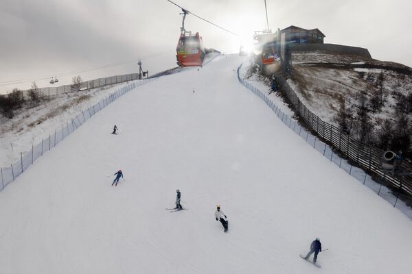 Лыжники спускаются со склона на горнолыжном курорте Тайву в Чжанцзякоу недалеко от мест проведения зимних Олимпийских игр в Пекине 2022 года. - Sputnik Азербайджан