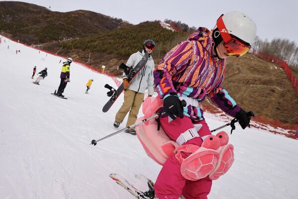 Посетители катаются на лыжах и сноубордах на горнолыжном курорте Гентинг в Чжанцзякоу, недалеко от мест проведения зимних Олимпийских игр. - Sputnik Азербайджан