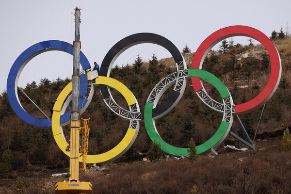 Рабочие собирают олимпийские кольца на площадке для катания на лыжах на зимних Олимпийских играх в Пекине. - Sputnik Азербайджан