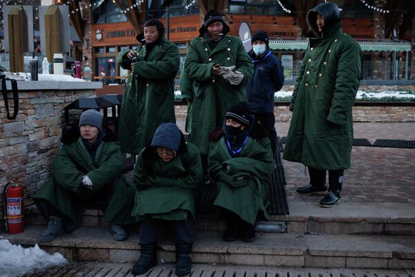Рабочие в традиционных армейских пальто на горнолыжном курорте Тайву в Чжанцзякоу, недалеко от мест проведения зимних Олимпийских игр в Пекине. - Sputnik Азербайджан