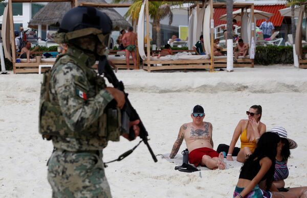 Военнослужащий ВМС патрулирует пляж в рамках мер безопасности на отдыхе в туристической зоне Канкуна, Мексика. - Sputnik Азербайджан