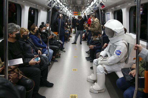 Мужчина в костюме астронавта едет в метро в рамках кампании по продвижению космической выставки НАСА в Стамбуле, Турция. - Sputnik Азербайджан