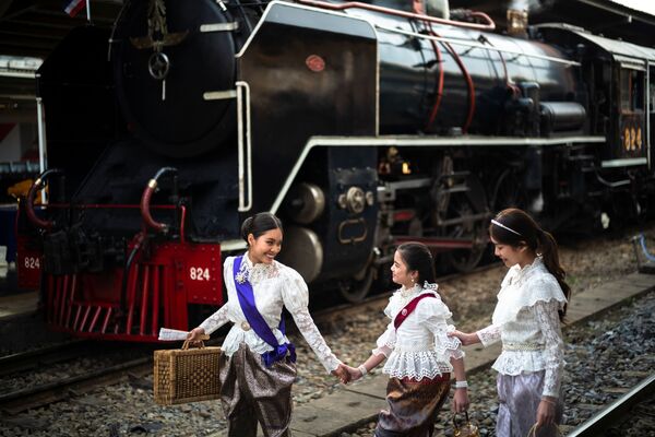Женщины в старинных платьях позируют рядом с паровозом в Бангкоке, Таиланд. - Sputnik Азербайджан