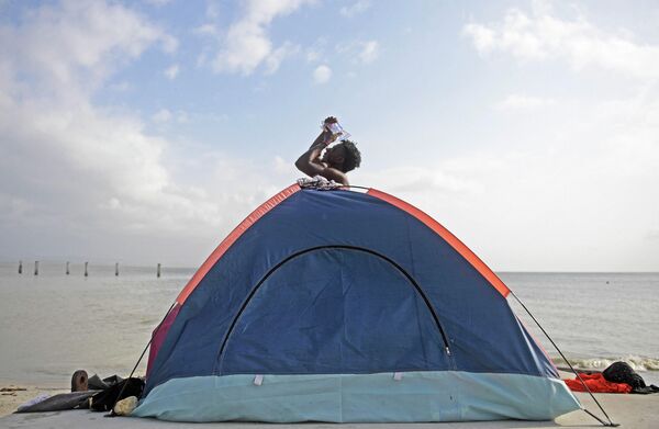 Мужчина в ​​импровизированном лагере, установленном мигрантами в Некокли, Колумбия. - Sputnik Азербайджан