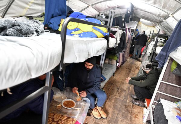 Мигранты едят в палатке в лагере для мигрантов «Липа», который был восстановлен после пожара в декабре 29 января 2021 года недалеко от северо-западного боснийского города Бихач. - Sputnik Азербайджан