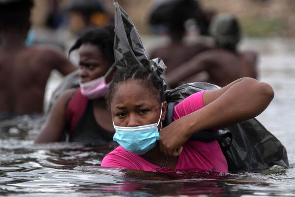 Гаитянские мигранты пересекают реку Рио-Гранде, чтобы получить еду и воду в Мексике. - Sputnik Азербайджан