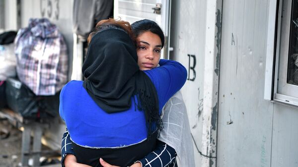 Афганские беженки обнимаются в лагере Вати в Греции - Sputnik Азербайджан